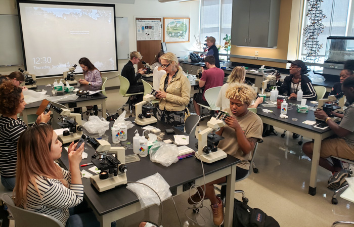 students in biology lab with microscopes